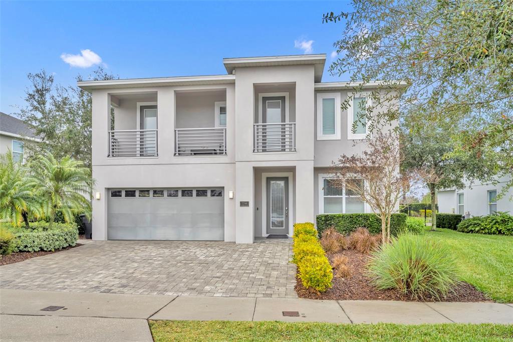 A two-story house with a paved driveway, a two-car garage, and a second-floor balcony — 7744 FAIRFAX DRIVE, KISSIMMEE, FL