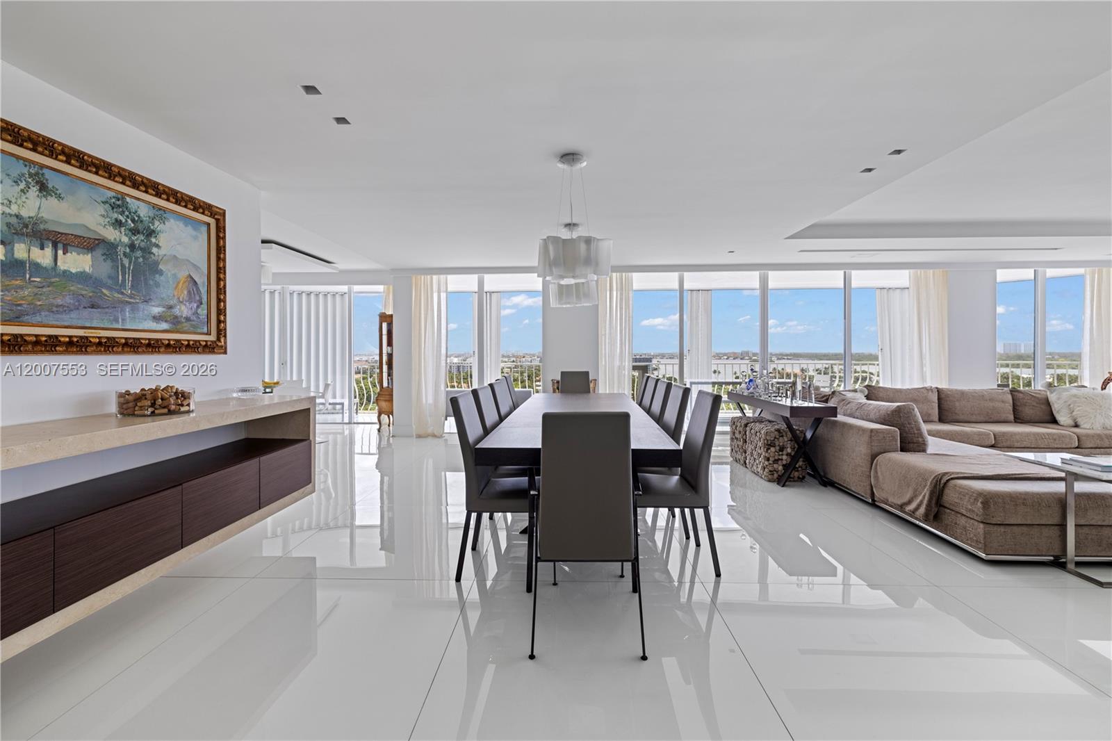 A modern dining and living area features white tile floors, floor-to-ceiling windows, and ocean views — 10155 Collins Ave # 1210, Bal Harbour FL 33154, BAL HARBOUR, FL