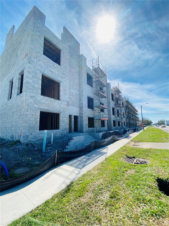 A multi-story building under construction features concrete block walls, scaffolding, and a sidewalk in front — 4723 W PRICE AVENUE UNIT 2, TAMPA, FL