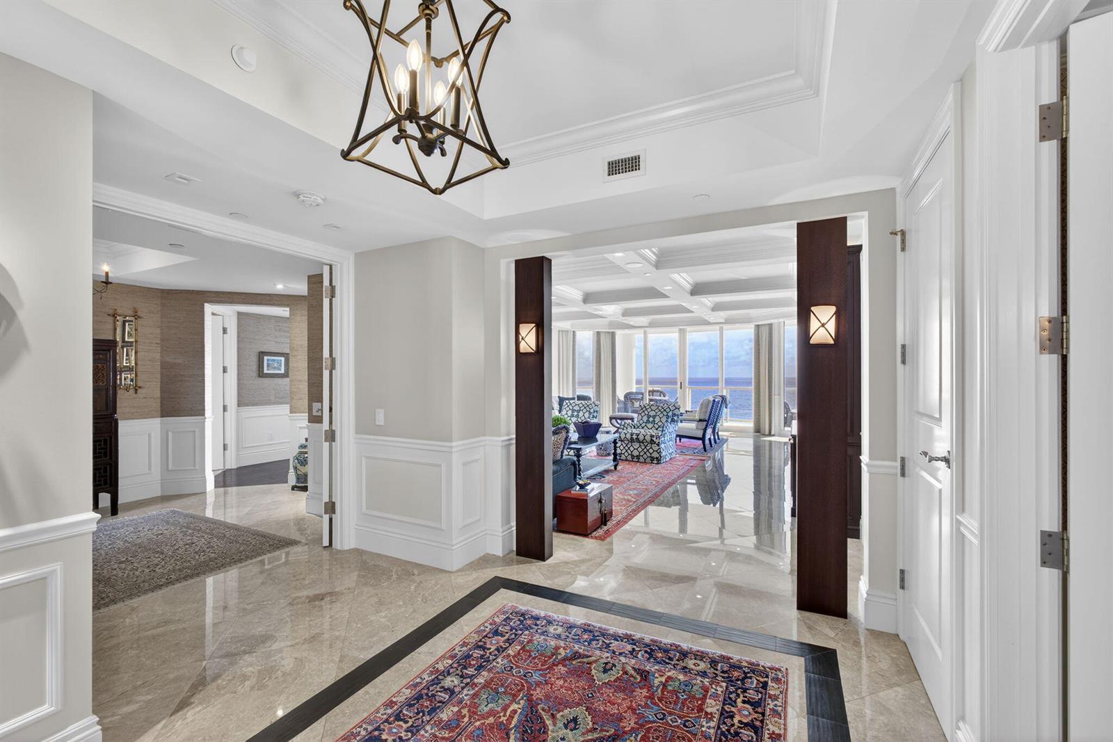 A marble-floored foyer leads through dark wood pillars into a living room with ocean views — 2700 N Ocean Drive # 1401a, Riviera Beach FL 33404, RIVIERA BEACH, FL