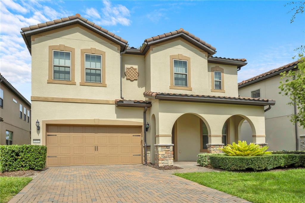 A two-story stucco house with a tile roof, arched entryway, and a two-car garage — 11322 LEMON LAKE BOULEVARD, ORLANDO, FL