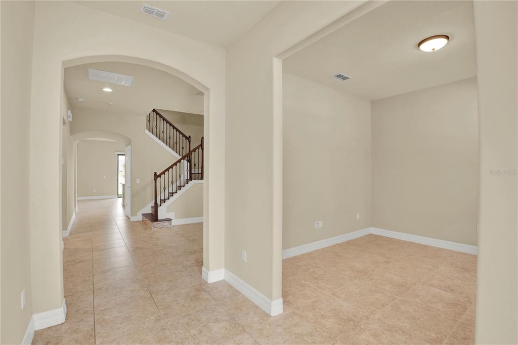 An interior view showing a tiled entryway, a staircase, and an adjacent room — 11322 LEMON LAKE BOULEVARD, ORLANDO, FL
