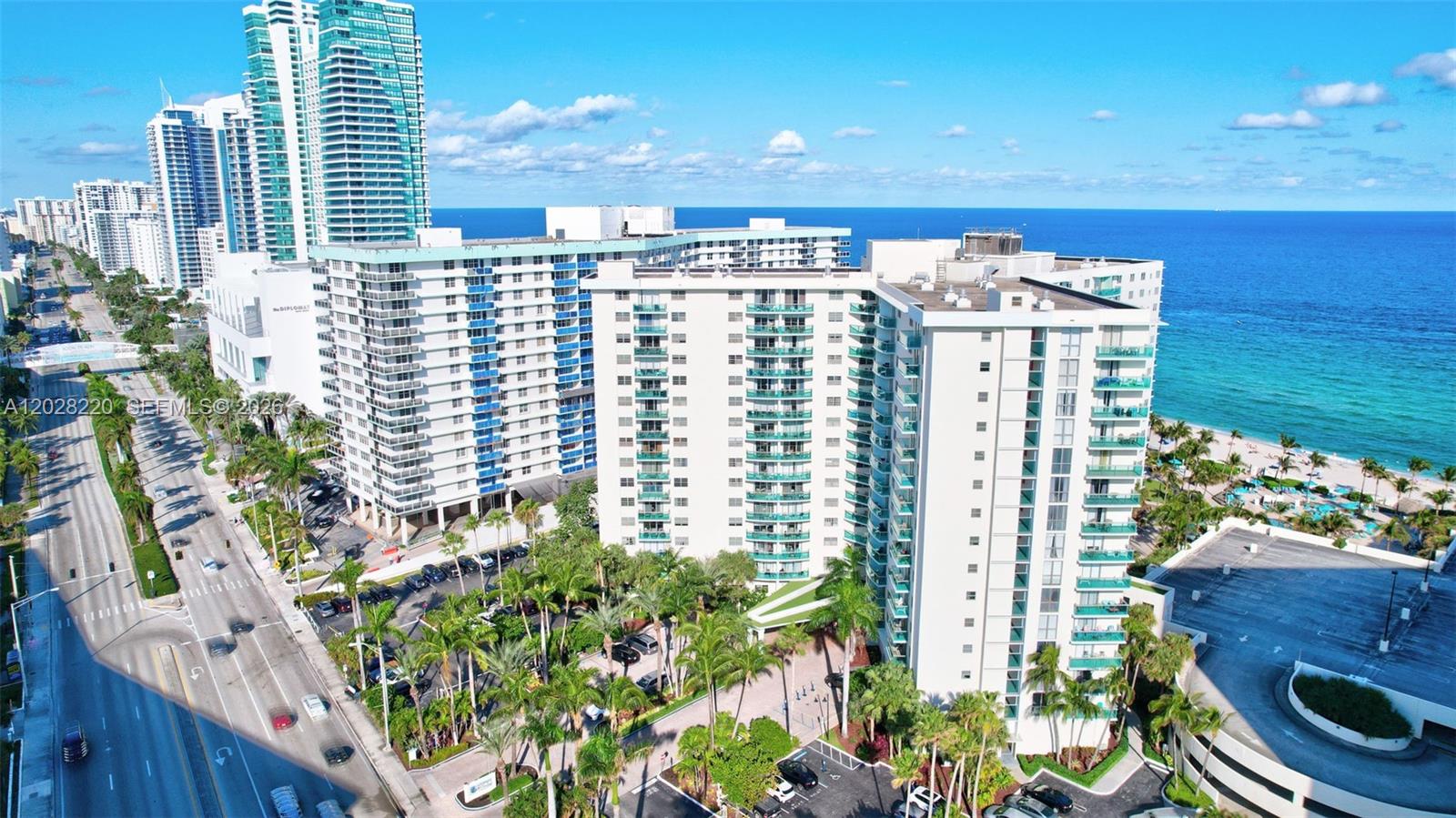 An aerial view shows a large white apartment complex situated next to the ocean — 3801 S Ocean Dr # 6Z, Hollywood FL 33019, HOLLYWOOD, FL