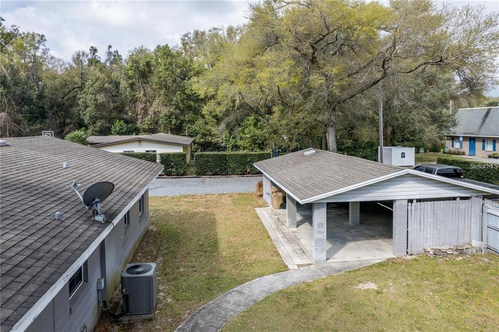 An elevated view shows a house roof, a detached carport, and a grassy backyard area — 25525 COLMAR AVENUE, SORRENTO, FL
