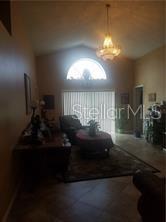 A living room with a vaulted ceiling, a chandelier, and a large arched window — 11712 HATCHER CIRCLE, ORLANDO, FL