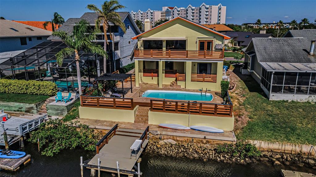 An aerial view of a waterfront house with a pool, wooden deck, and private dock — 6009 BAYWAY COURT, NEW PORT RICHEY, FL