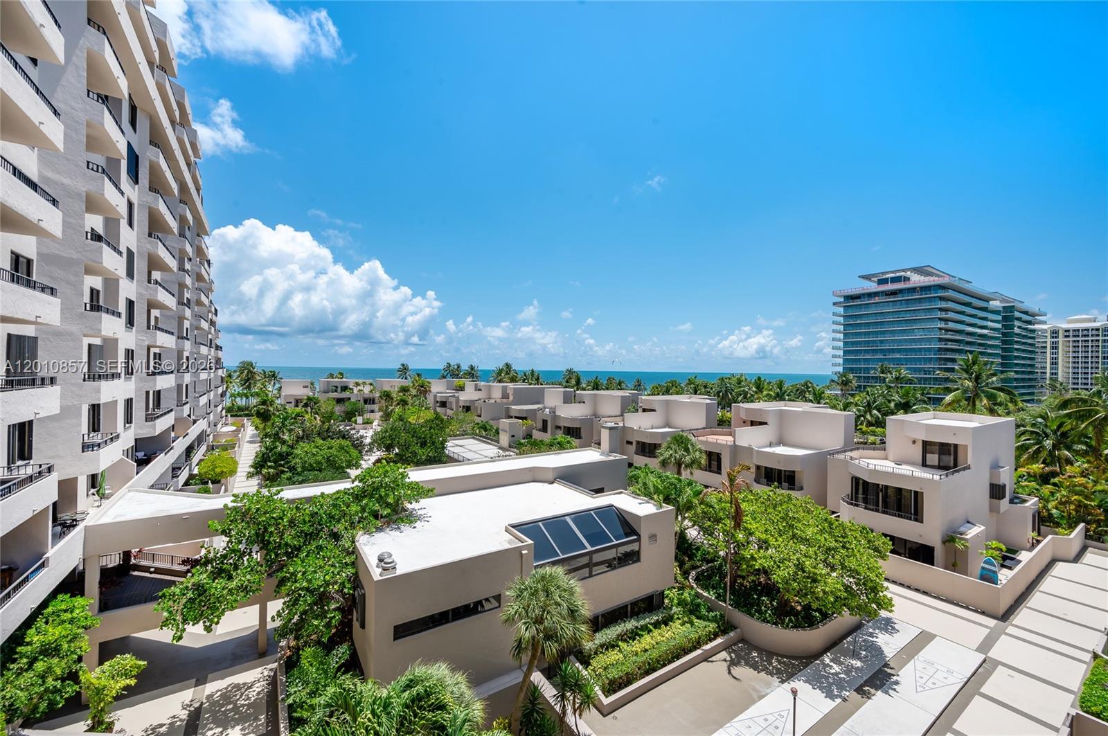 An elevated view shows a residential complex with low-rise buildings, lush landscaping, and ocean views — 201 Crandon Blvd # 505, Key Biscayne FL 33149, KEY BISCAYNE, FL