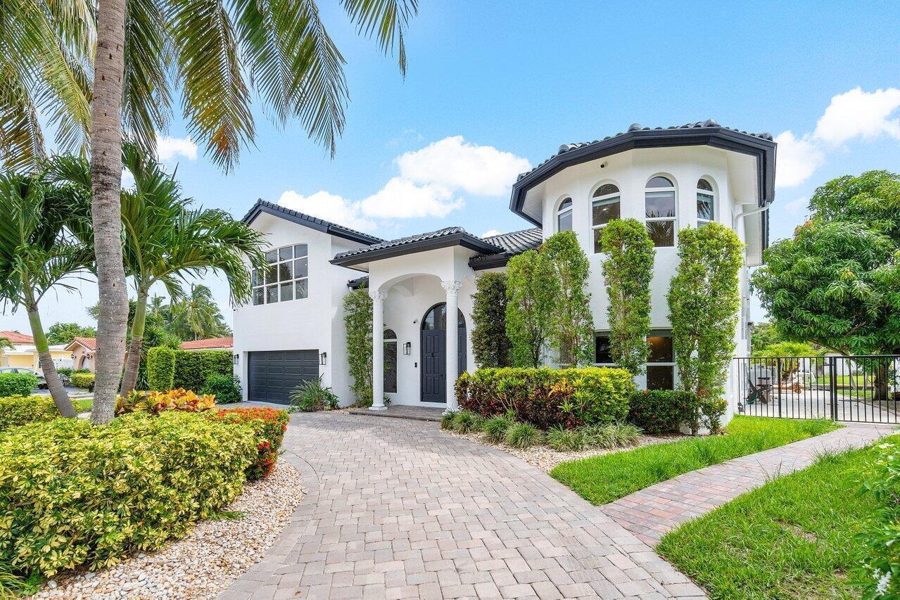 A two-story white house with a dark roof, arched entryway, and a paved driveway — 1366 SW 4th Court, Boca Raton FL 33432, BOCA RATON, FL