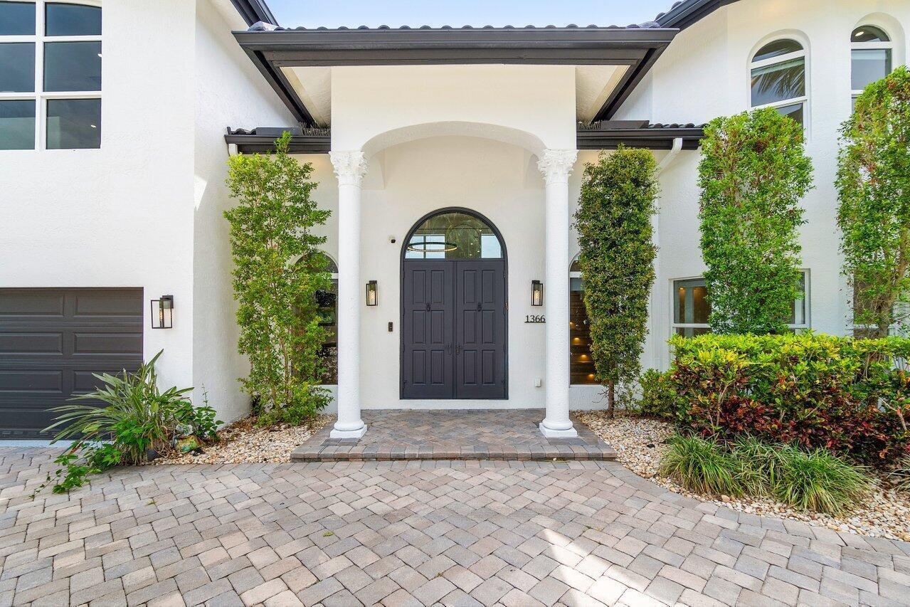 A white house exterior features a dark double door entrance with two white columns — 1366 SW 4th Court, Boca Raton FL 33432, BOCA RATON, FL