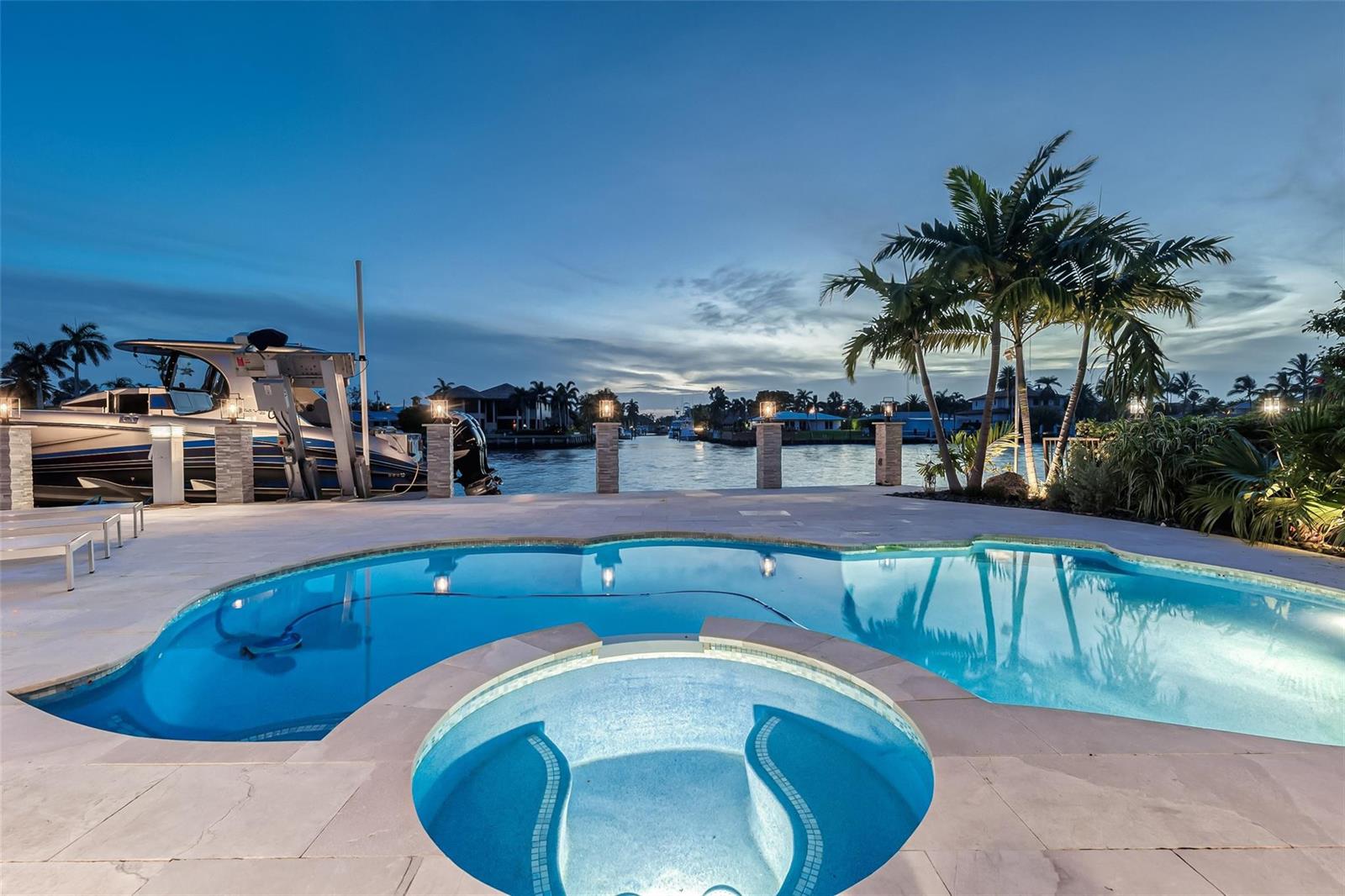 A swimming pool and hot tub overlook a canal with a boat docked at sunset — 2005 N Riverside Drive, Pompano Beach FL 33062, POMPANO BEACH, FL