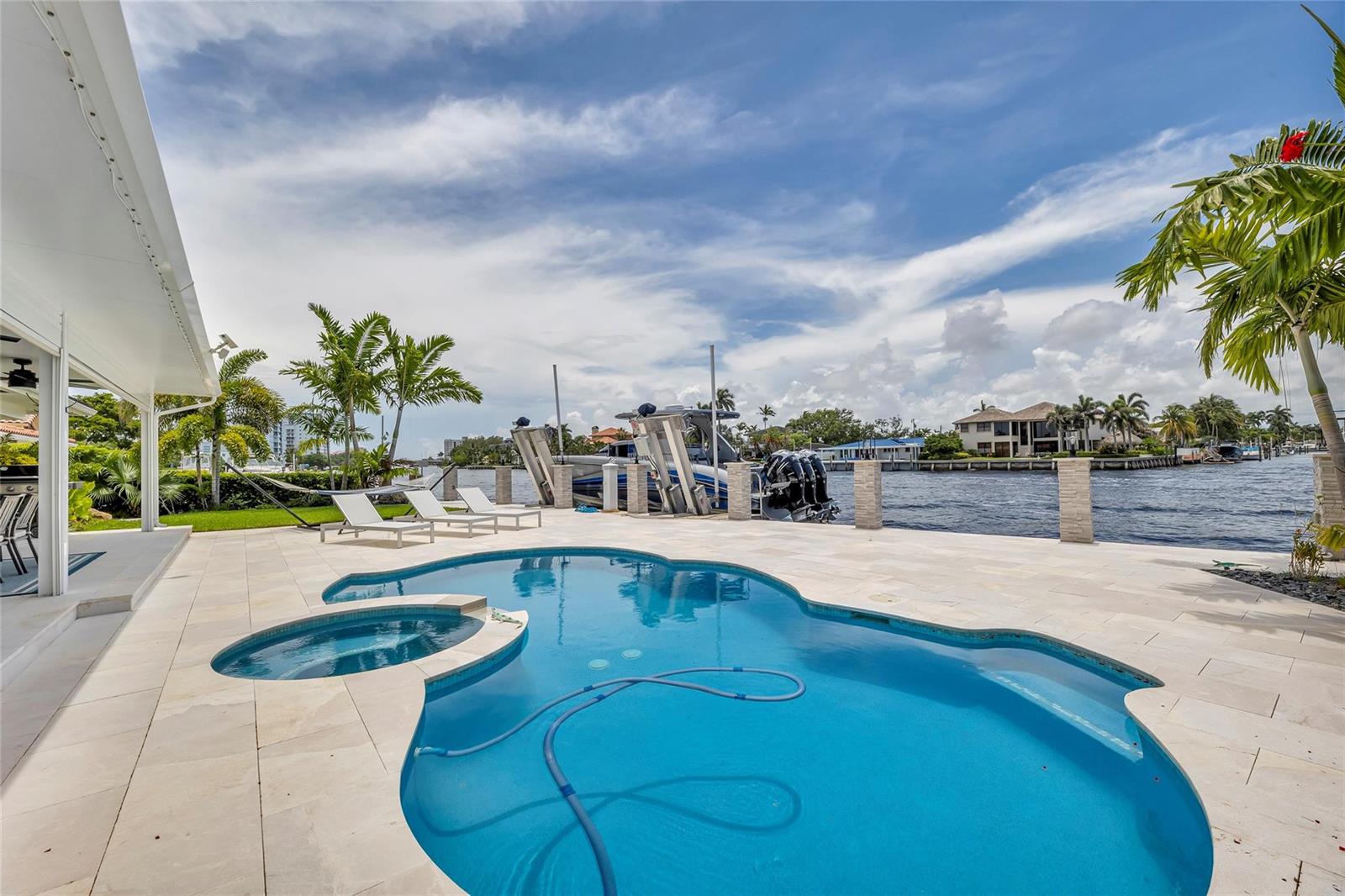 A swimming pool and hot tub sit on a stone patio overlooking a canal — 2005 N Riverside Drive, Pompano Beach FL 33062, POMPANO BEACH, FL