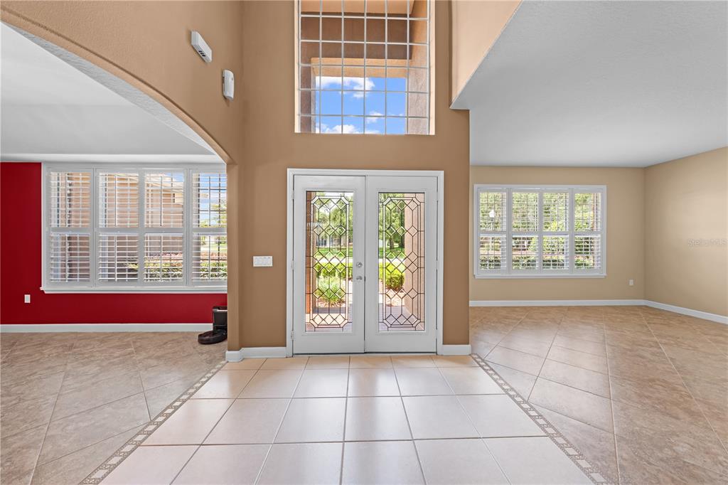 A bright entryway features tile flooring, a double front door, and a high ceiling — 1620 MARINA LAKE DR, KISSIMMEE, FL