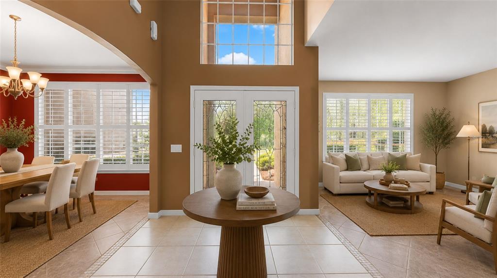 A bright foyer features a round pedestal table, tiled floors, and a double front door — 1620 MARINA LAKE DR, KISSIMMEE, FL