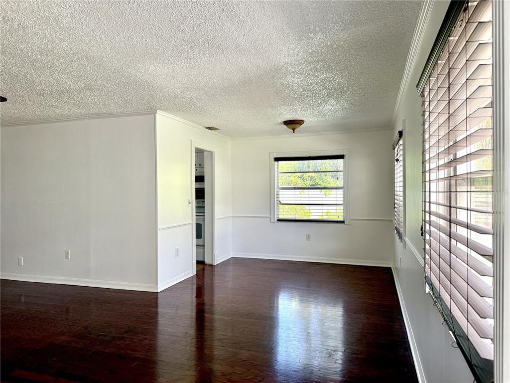 An empty room with dark hardwood floors, white walls, and a window with wooden blinds — 350 79TH AVE N UNIT 102, ST PETERSBURG, FL