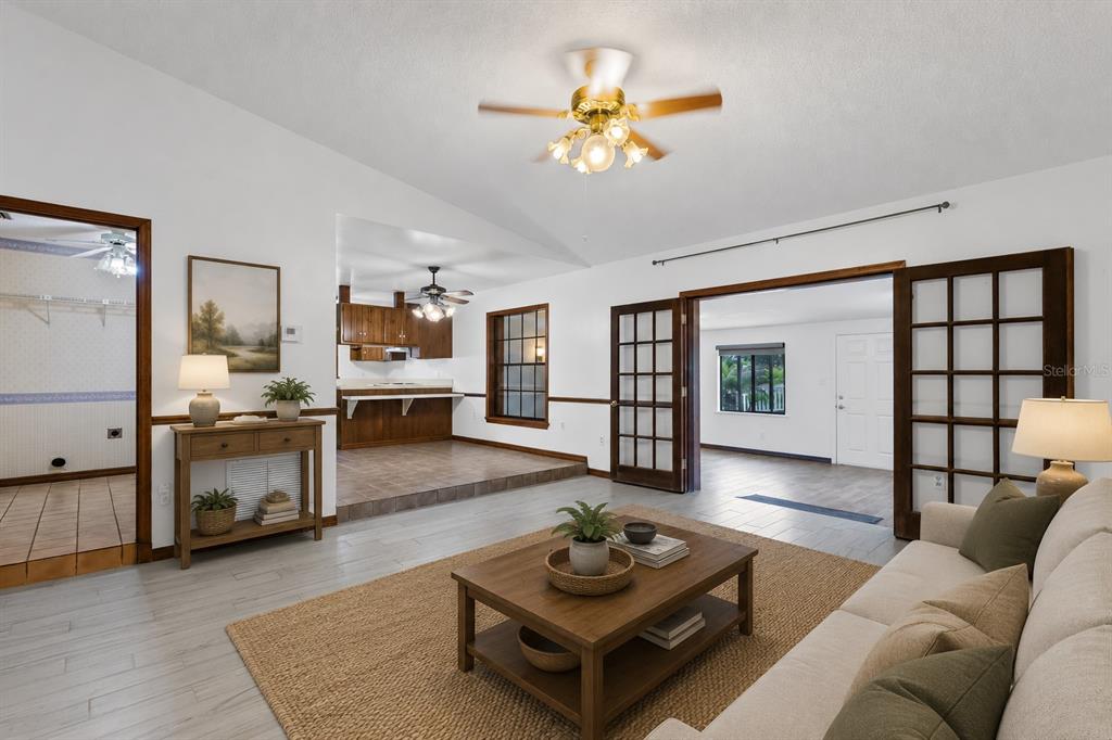 A living room with light tile floors, a ceiling fan, and French doors leading outside — 17531 N SUNSET TERRACE, WINTER GARDEN, FL