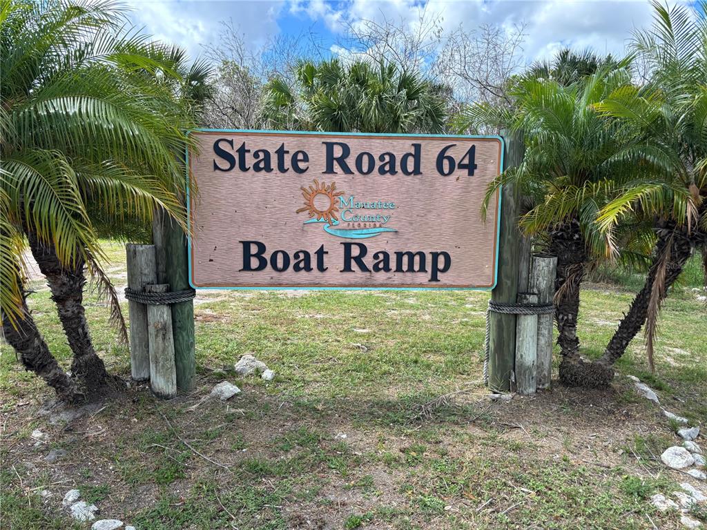 A wooden sign for the State Road 64 Boat Ramp stands between two palm trees — 716 32ND STREET COURT E, BRADENTON, FL