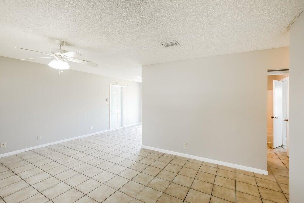 An interior view of a room with beige tile flooring, light walls, and a ceiling fan — NORTH LAUDERDALE, FL