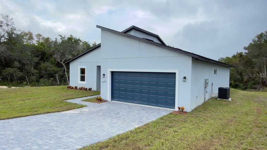 A single-story house with a blue garage door, light gray exterior, and a paved driveway — 14905 SW 24TH CIRCLE, OCALA, FL