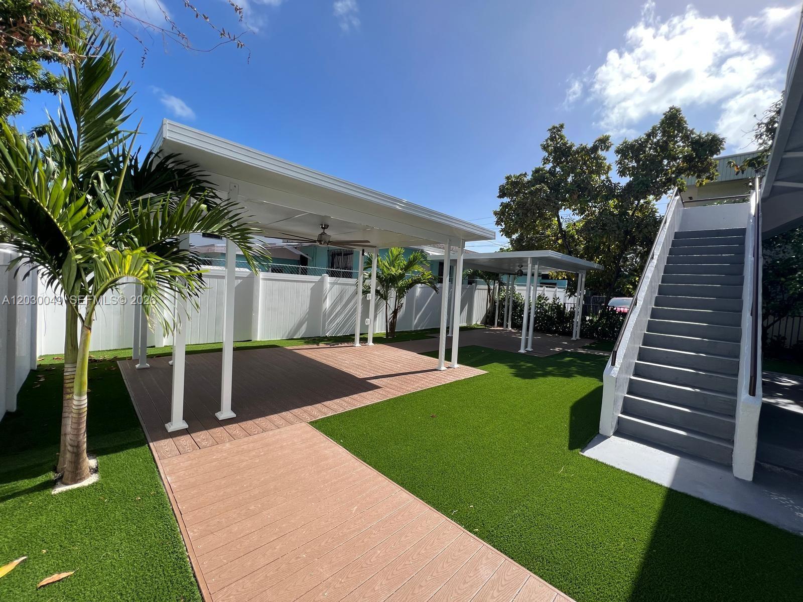 A backyard features a wooden deck, artificial turf, two covered patios, and an outdoor staircase — 331 SW 11th Ave, Miami FL 33130, MIAMI, FL