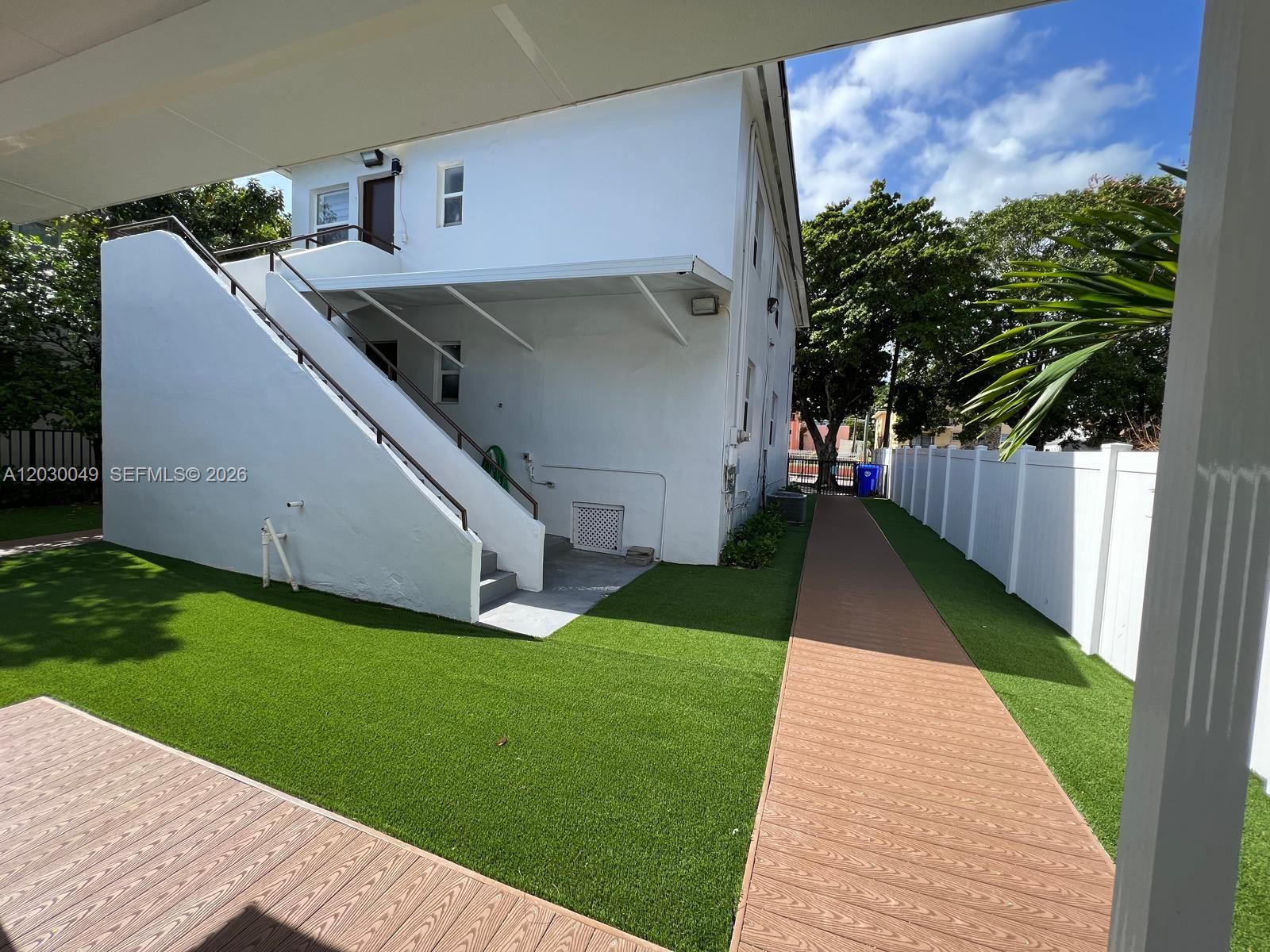 A white building features an exterior staircase, artificial turf, and a wooden walkway — 331 SW 11th Ave, Miami FL 33130, MIAMI, FL