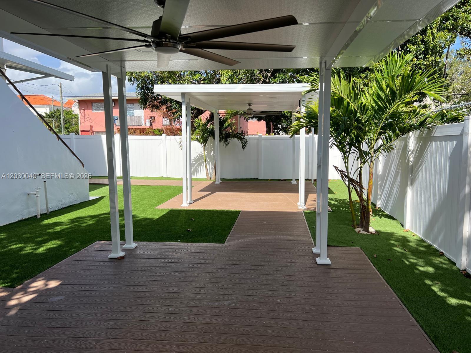 A backyard features two covered patios with ceiling fans, artificial turf, and white vinyl fencing — 331 SW 11th Ave, Miami FL 33130, MIAMI, FL
