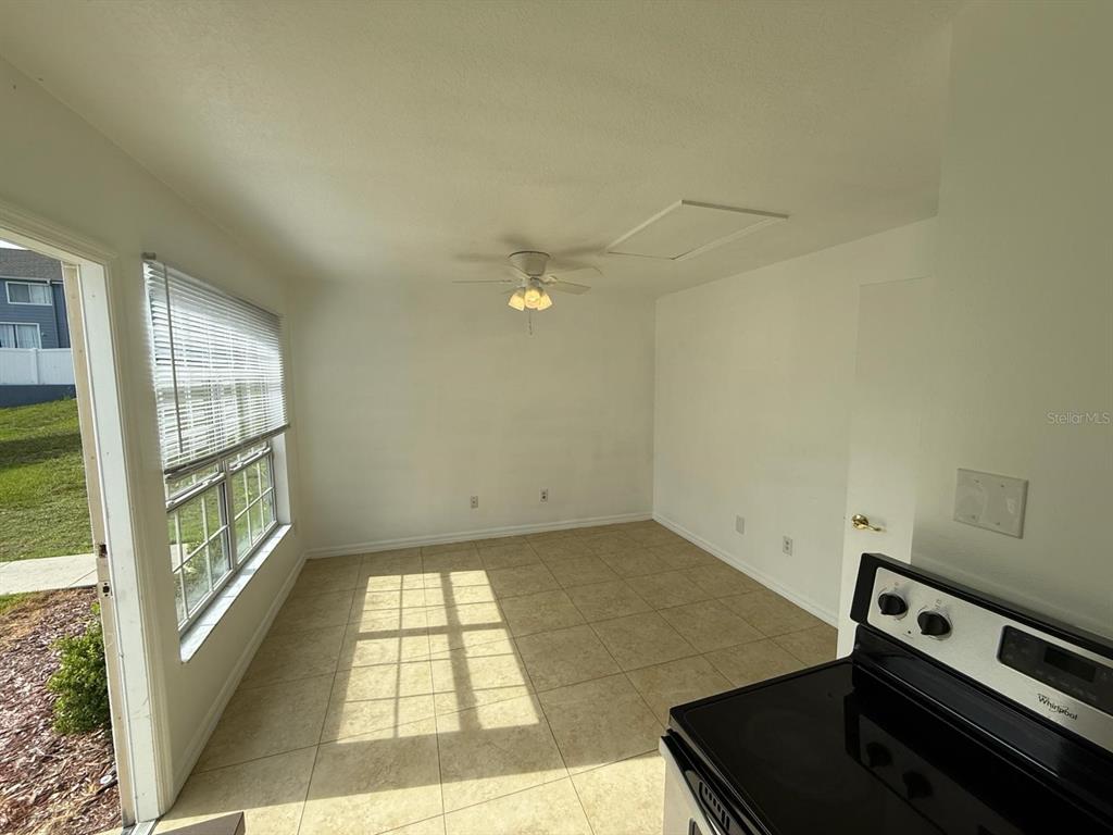A kitchen dining area features tile flooring, a ceiling fan, and a sliding glass door — 316 MANGO DRIVE UNIT B, DAVENPORT, FL