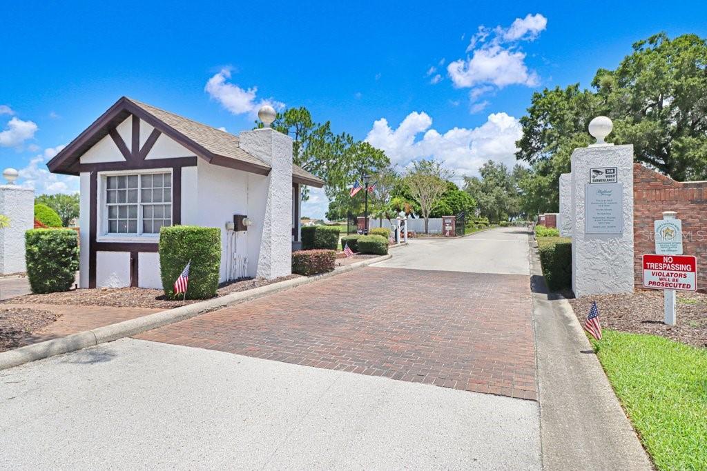 A gated community entrance features a brick driveway, a guardhouse, and a no trespassing sign — 3250 PEBBLE BEND DRIVE, LAKELAND, FL