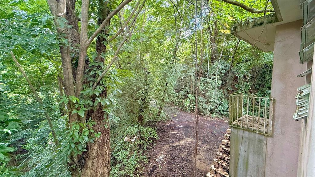 An exterior view of a building corner with a small balcony overlooking a wooded area — KM 14.5 KM 14.5, CIALES, PR