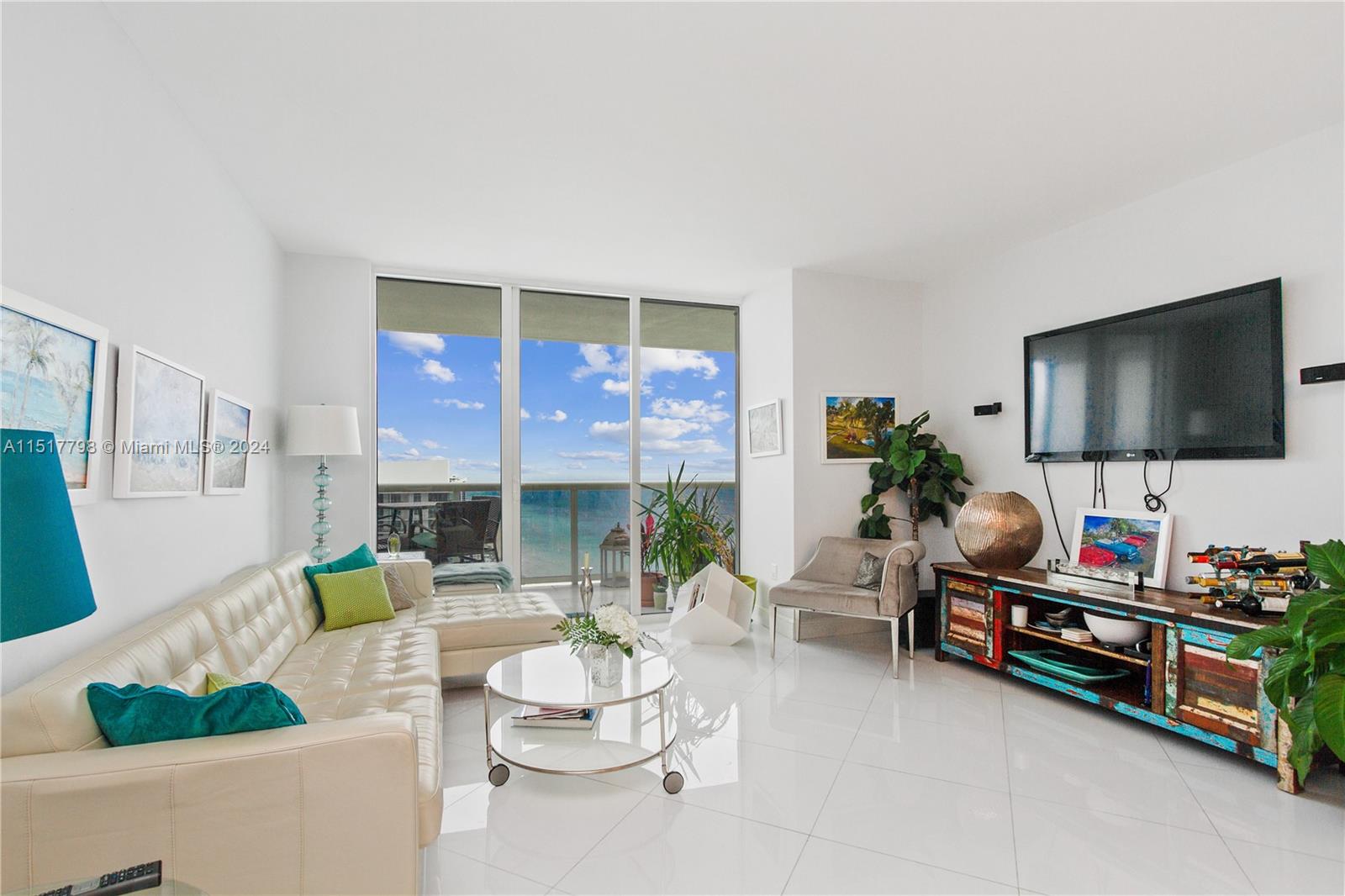 A bright living room features white tile floors, a sectional sofa, and floor-to-ceiling ocean views — 1830 S Ocean Dr, Hallandale Beach FL 33009, HALLANDALE BEACH, FL