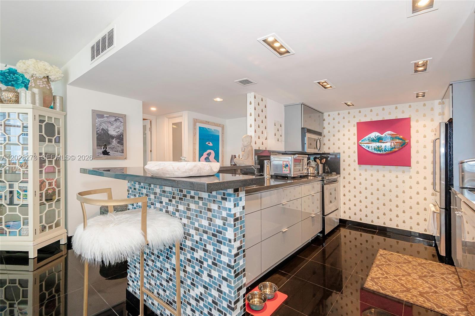 A kitchen features a blue mosaic tile breakfast bar, glossy cabinets, and black tile flooring — 11 Island Ave # 409, Miami Beach FL 33139, MIAMI BEACH, FL