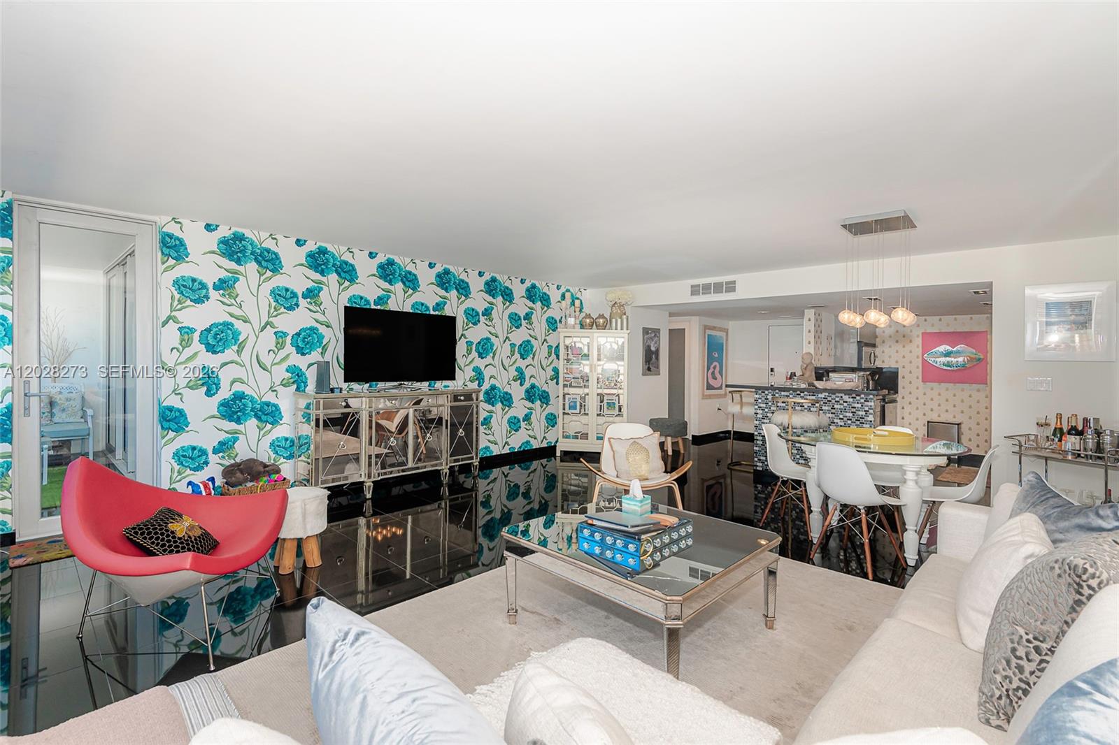A living room features floral wallpaper, a mirrored console, black tile floors, and a dining area — 11 Island Ave # 409, Miami Beach FL 33139, MIAMI BEACH, FL