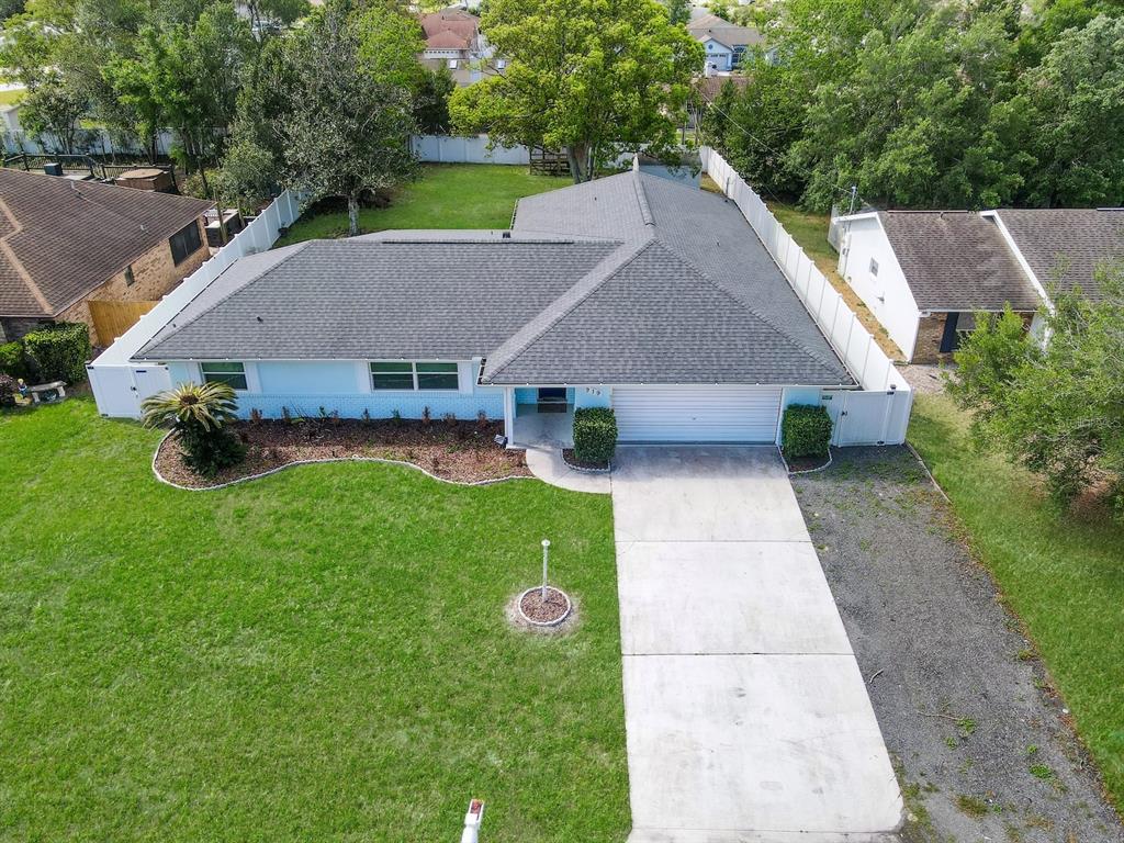 An aerial view of a single-story house with a light blue exterior and gray roof — 919 SYLVIA DRIVE, DELTONA, FL