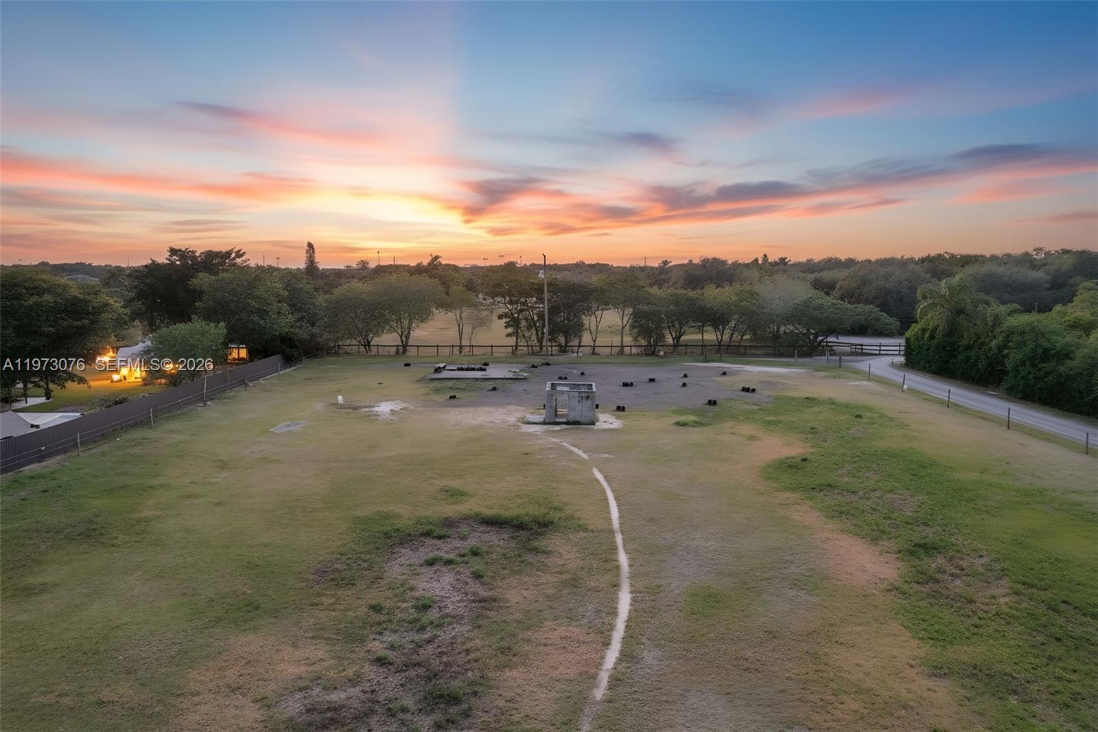 An aerial view shows a large, grassy lot with a small concrete structure at sunset — 25730 SW 153 CT, Unincorporated Dade County FL 33032, UNINCORPORATED DADE COUNTY, FL