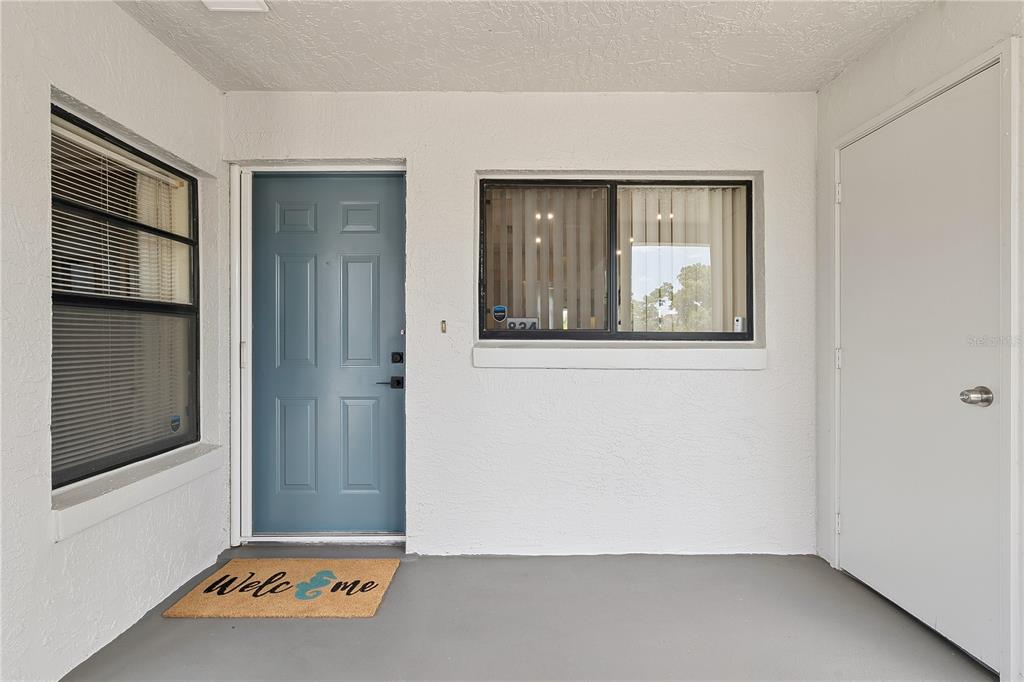 A covered entryway features a blue front door, a window, and a storage closet door — 1068 LOTUS PARKWAY UNIT 834, ALTAMONTE SPRINGS, FL