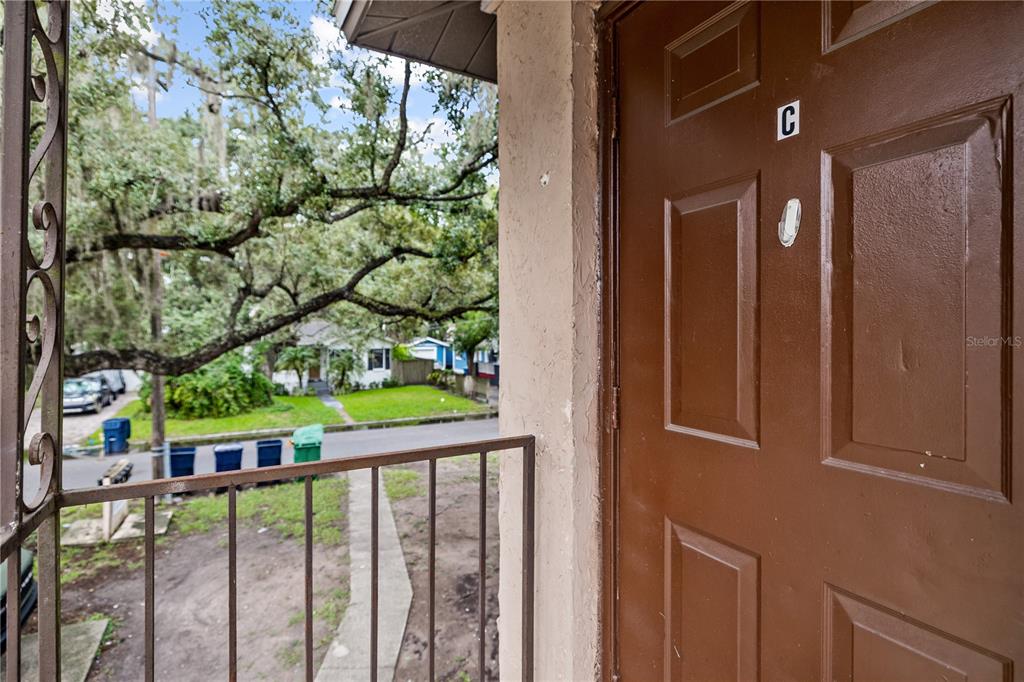 A brown door marked with the letter C opens onto a small outdoor porch — 1221 E MOHAWK AVENUE UNIT C, TAMPA, FL
