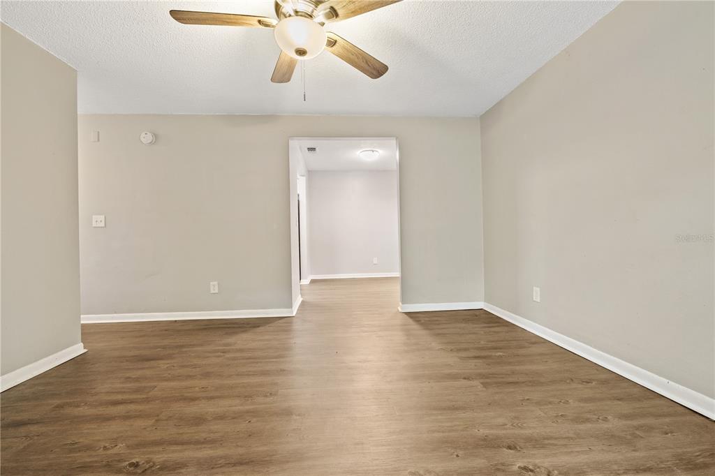 An empty room with light-colored walls, wood-look flooring, and a ceiling fan — 1221 E MOHAWK AVENUE UNIT C, TAMPA, FL