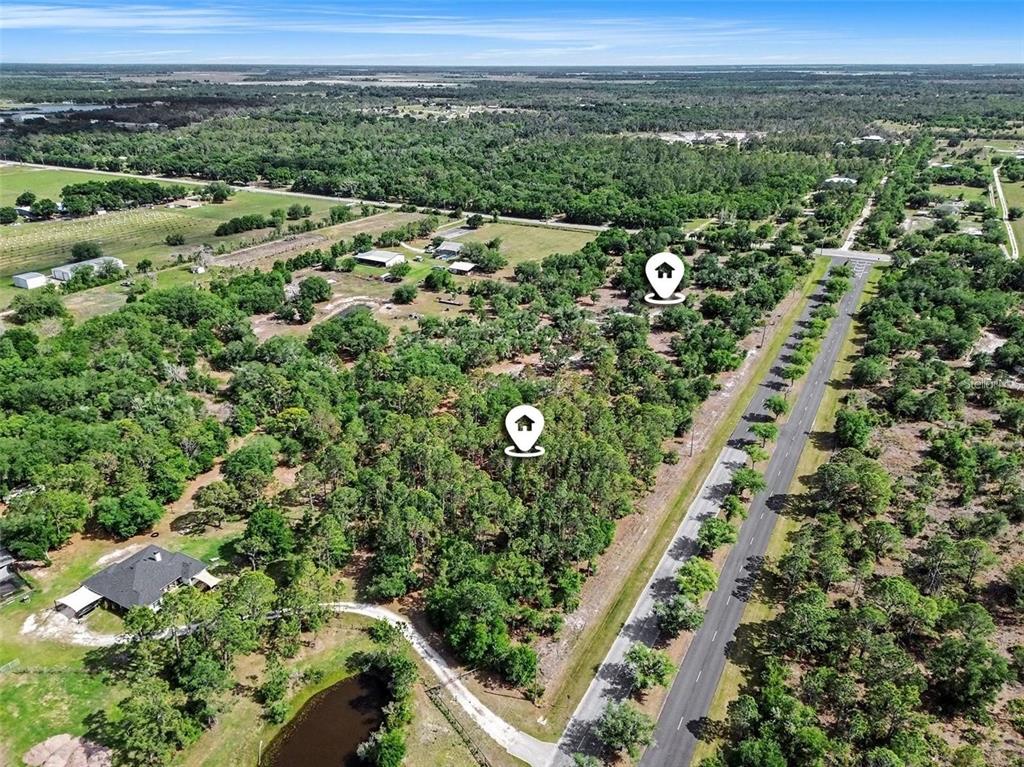 An aerial view shows a wooded lot with two location markers along a paved road — 41155 STATE RD 64 EAST, MYAKKA CITY, FL