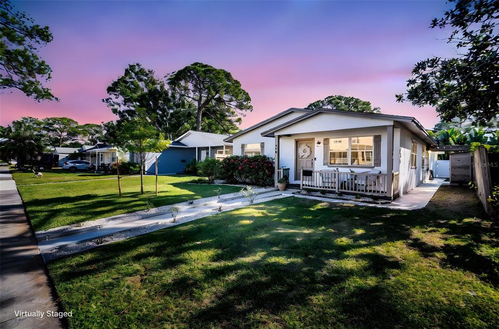 A single-story house with a white exterior, front porch, and a gravel walkway at sunset — 218 49TH AVENUE N, ST PETERSBURG, FL
