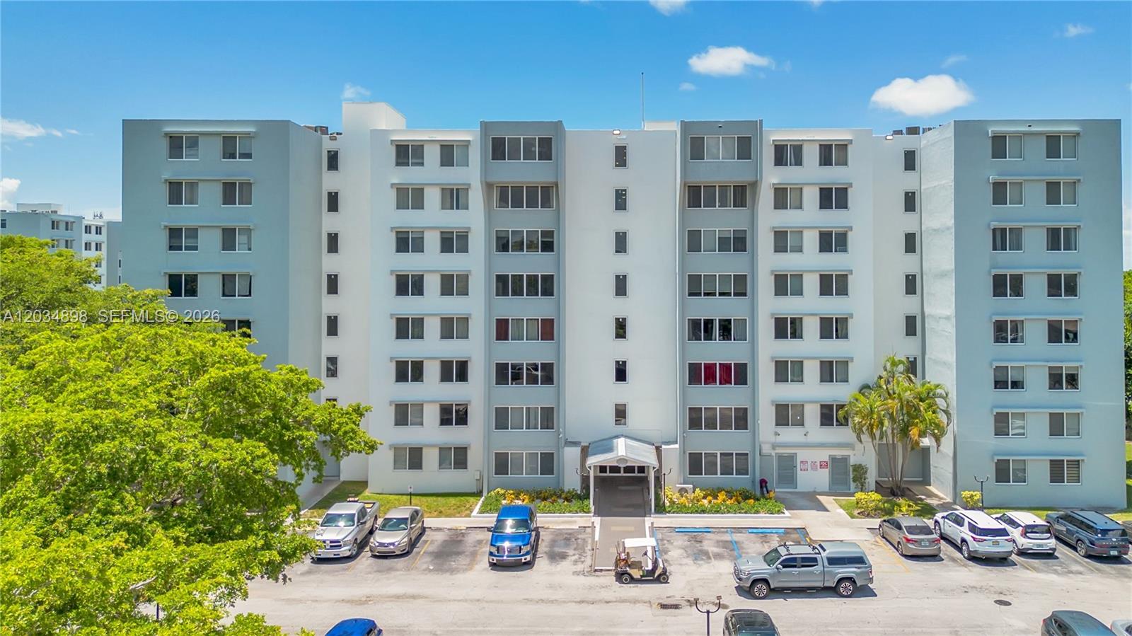 An exterior view of a multi-story apartment building with a parking lot in front — 9001 SW 77th Ave # C709, Miami FL 33156, MIAMI, FL