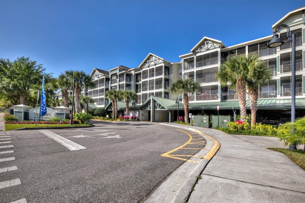 A multi-story apartment building with screened balconies and a covered parking area — 14200 AVALON ROAD UNIT 302, WINTER GARDEN, FL