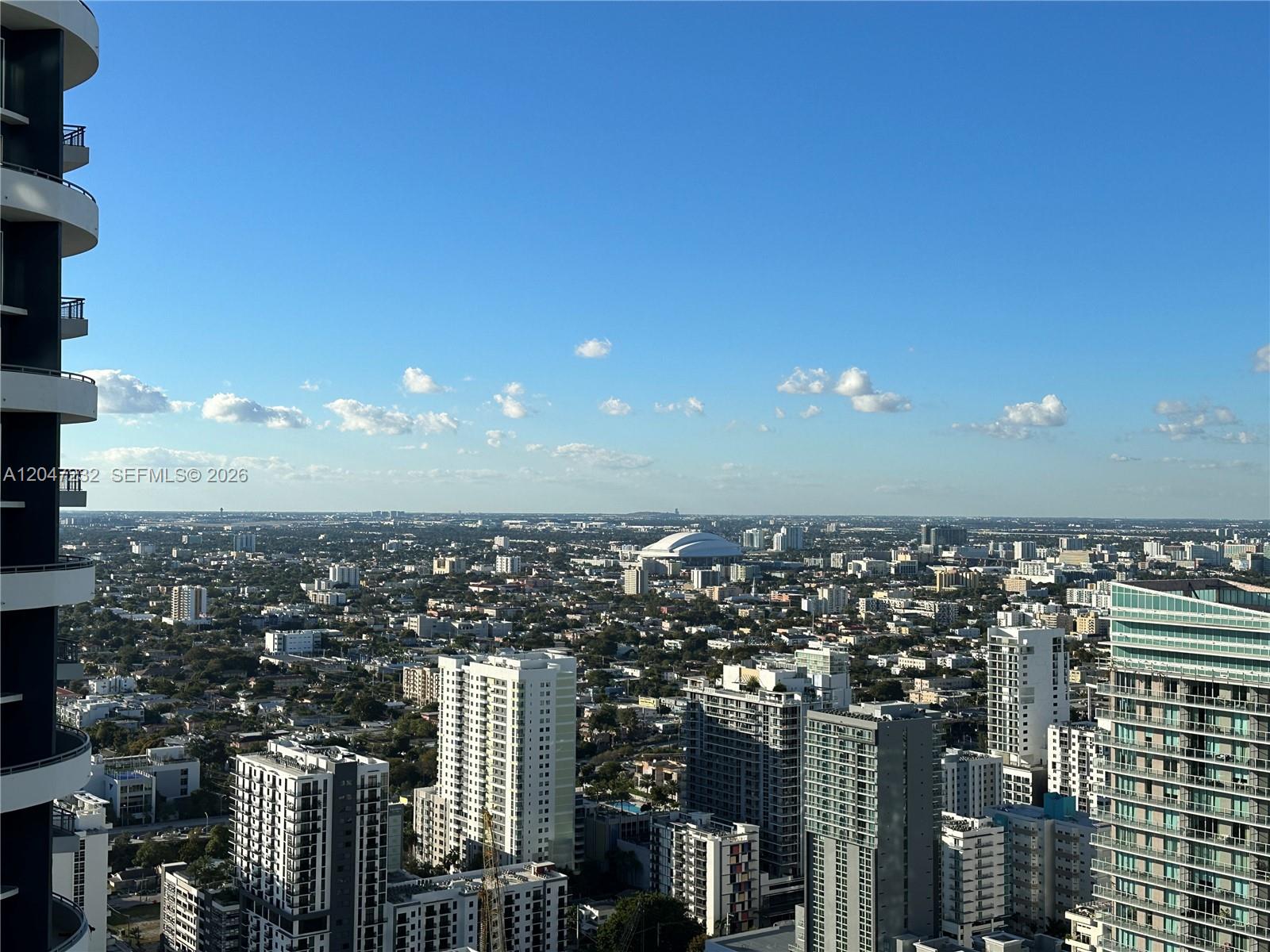 A high-angle view shows a dense urban cityscape with a prominent domed stadium — 1300 S Miami # 4209, Miami FL 33130, MIAMI, FL