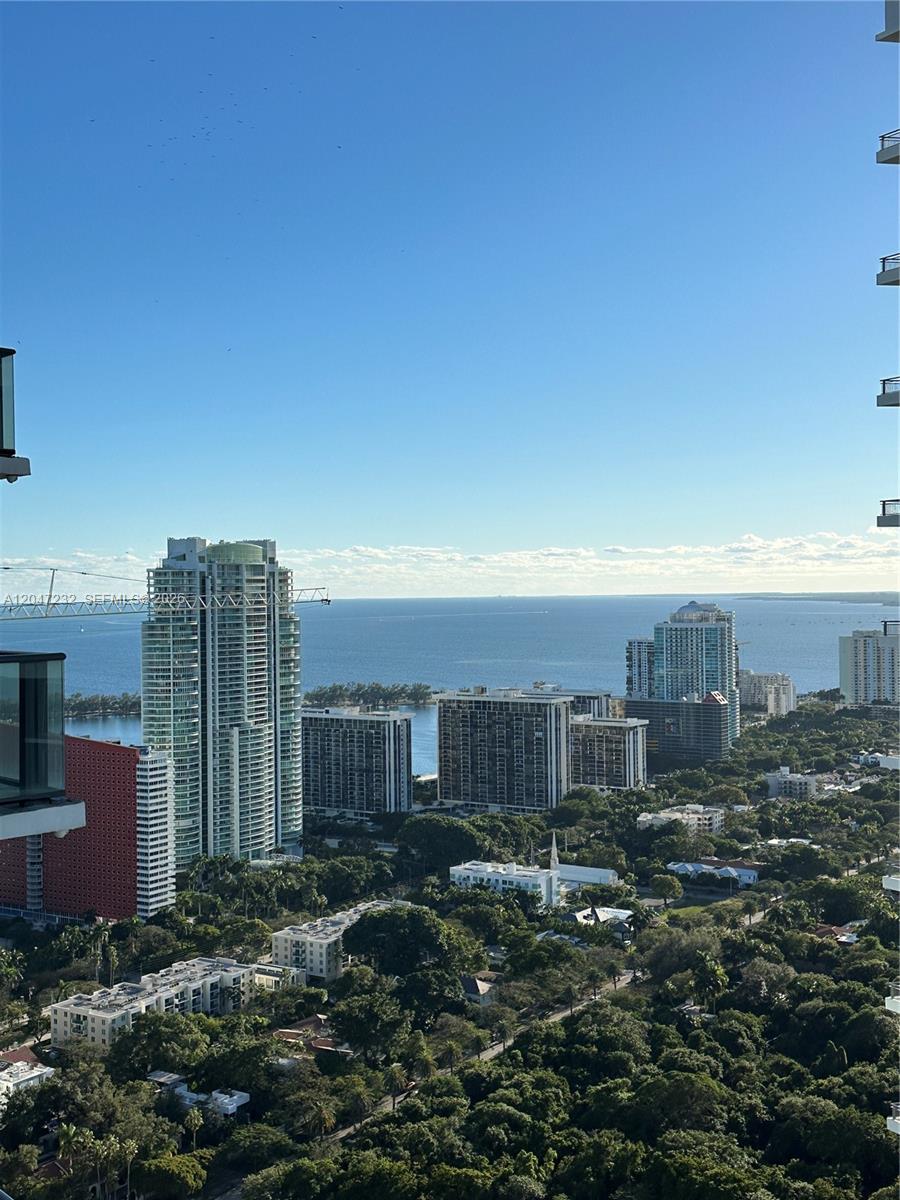 A high-angle view shows several residential towers and dense trees overlooking a large bay — 1300 S Miami # 4209, Miami FL 33130, MIAMI, FL