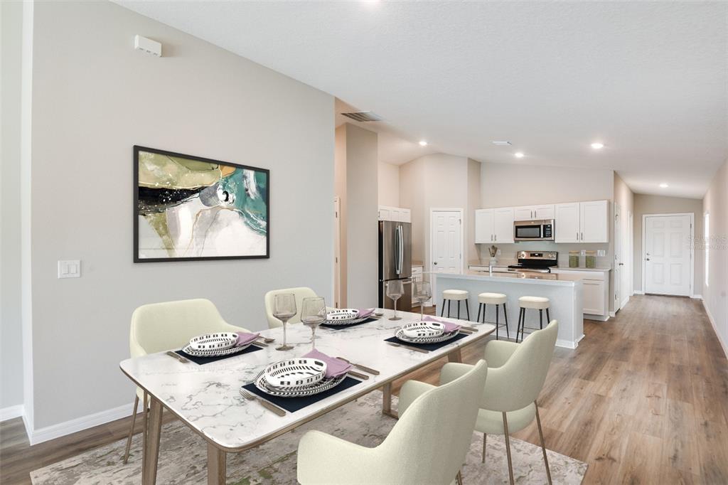 A dining area with a marble-topped table leads into an open-concept kitchen with white cabinetry — 6010 NAVONA WAY, WINTER HAVEN, FL