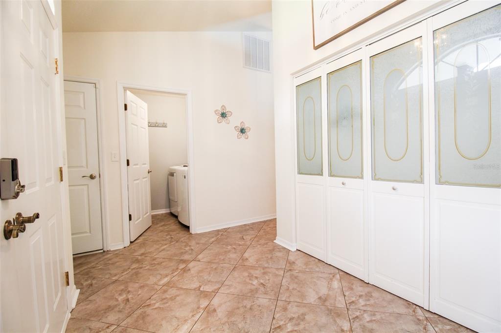 An entryway features tile flooring, a laundry room doorway, and a large four-panel closet — 6029 22ND AVENUE CIRCLE E, PALMETTO, FL