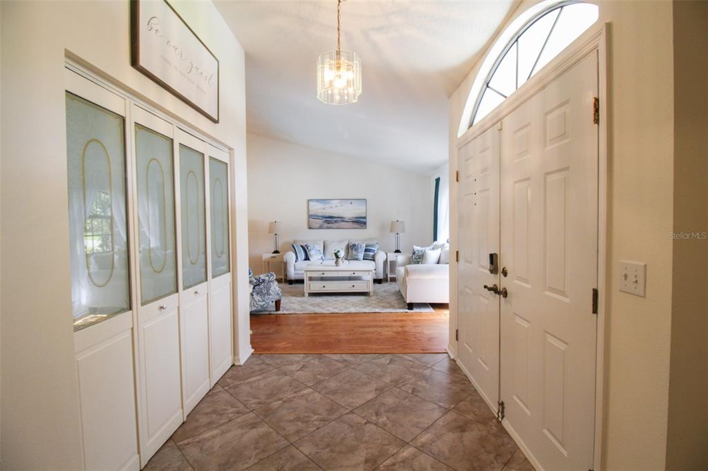 A tiled entryway leads into a living room with hardwood floors and a white sofa — 6029 22ND AVENUE CIRCLE E, PALMETTO, FL
