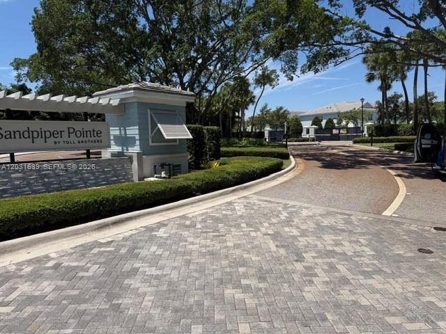 The entrance to the Sandpiper Pointe community features a stone sign and paved driveway — 581 Sanderling Cir # 581, Deerfield Beach FL 33442, DEERFIELD BEACH, FL