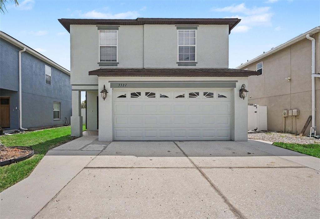 A paved patio area sits between two white privacy fences with a white picket fence beyond — 3327 THISTLEDOWN LANE, LAND O LAKES, FL