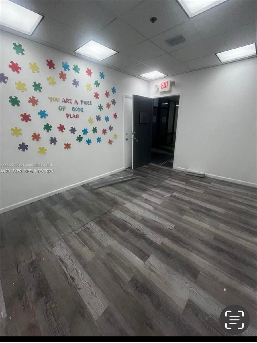An empty room features wood-look flooring and a wall decorated with colorful puzzle piece cutouts — 900 W 49th St Suite520, Hialeah FL 33012, HIALEAH, FL