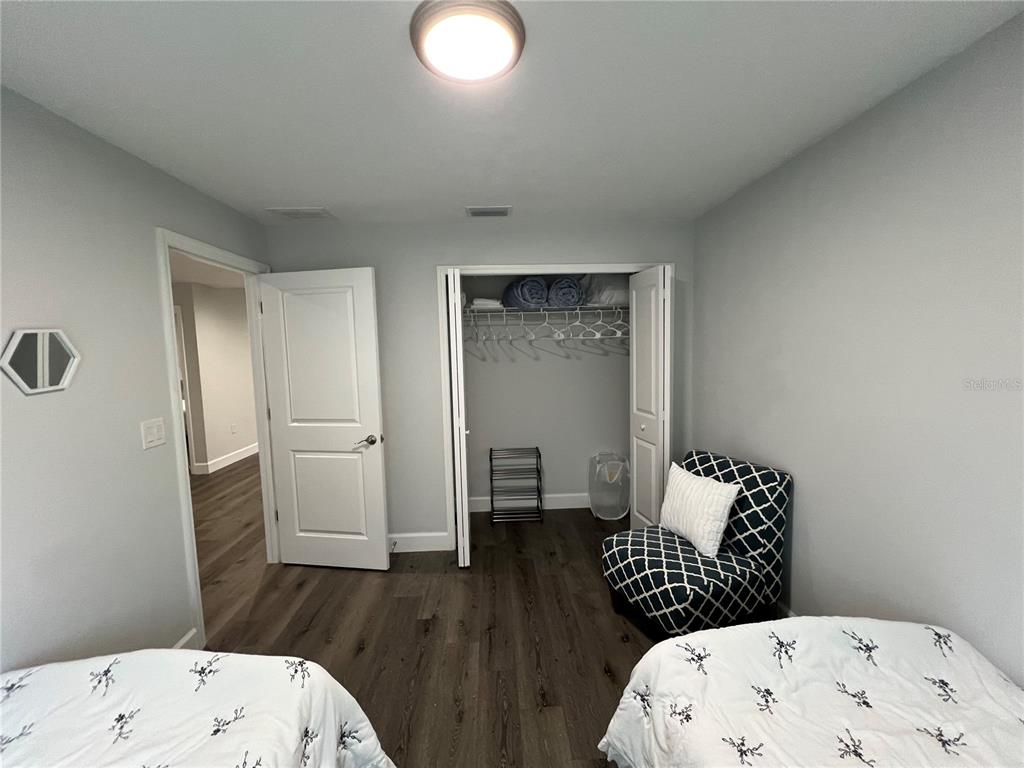 A bedroom with wood-look flooring, a closet, and two beds — 9092 AGATE STREET, PORT CHARLOTTE, FL