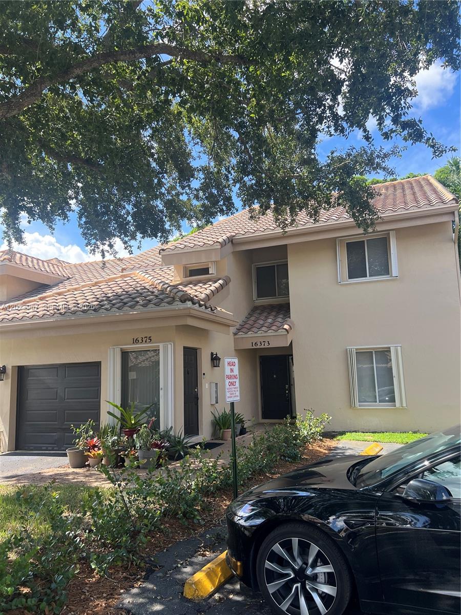 A two-story townhouse exterior with a tile roof, garage, and a "Head In Parking Only" sign — 16373 Malibu Dr # 51, Weston FL 33326, WESTON, FL